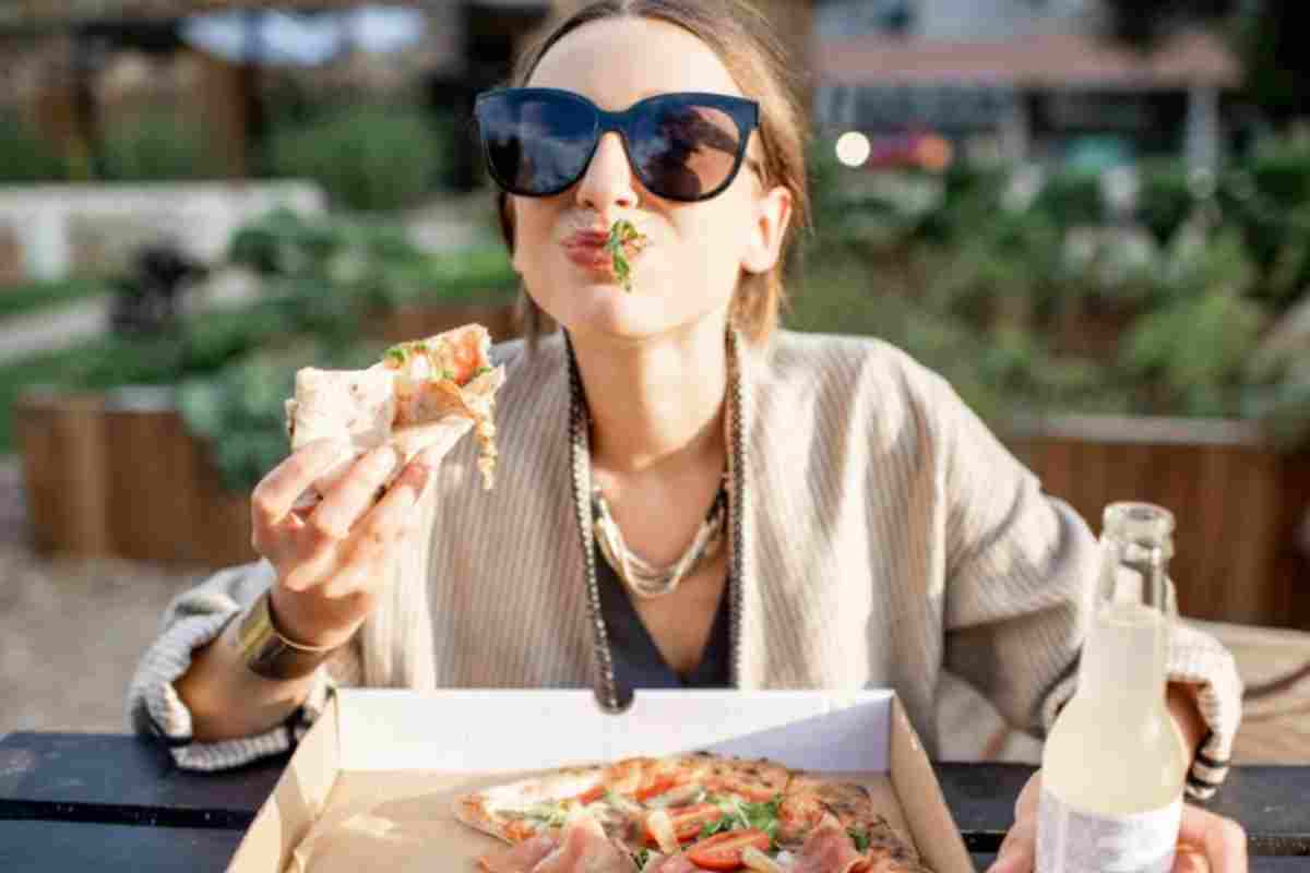 donna mangia la pizza con le mani